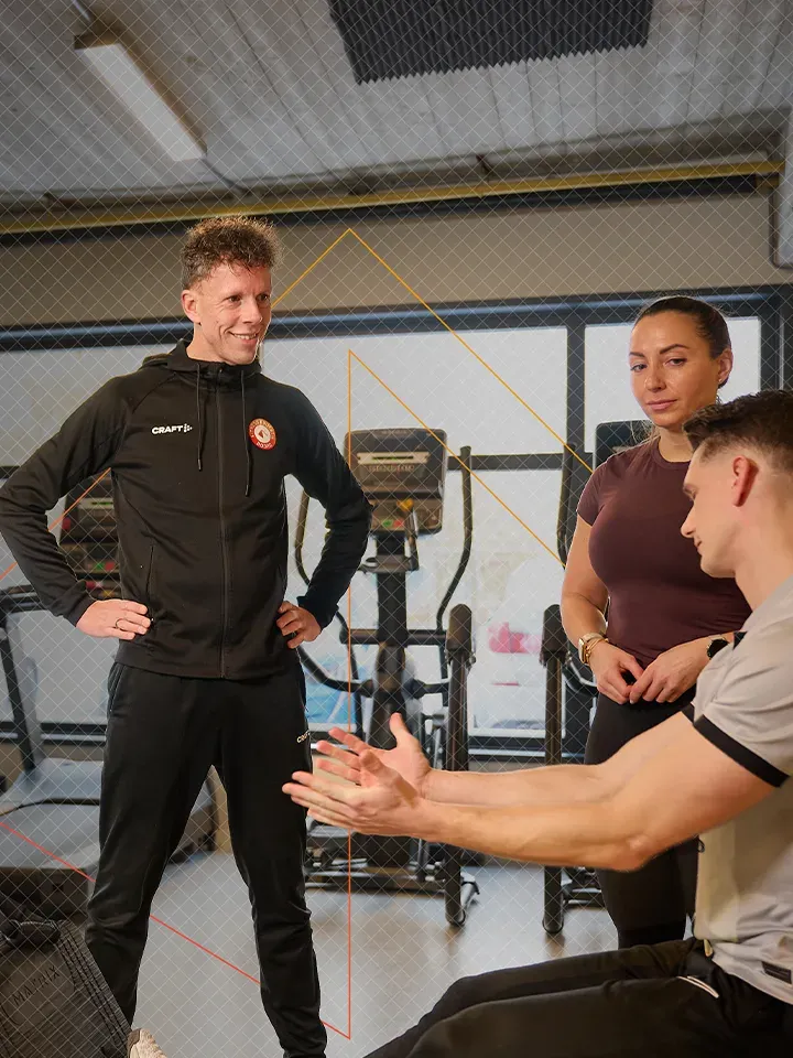 Trainer begeleidt cursisten bij Fitness Educatie Noord